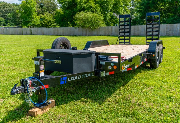 Heavy-duty equipment trailer with low deck and fold-up ramps for construction equipment hauling